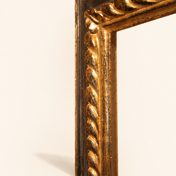 Corner detail of hand-carved gilded picture frame — twisted rope torus covered in 23-karat gold leaf, red bole patina showing through