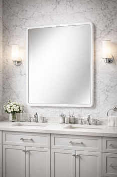 Bathroom mirror in a white frame with rounded corners above a double washbasin in a light bathroom with marble tiles