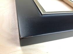 Mirror in black frame, partially gilded white gold leaf