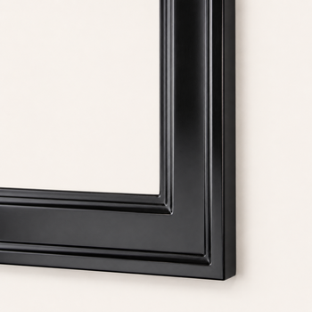 Corner detail of a black picture frame — wooden spline joint, stepped descent to the rabbet, satin sheen of shellac and wax