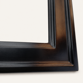 Corner detail of a black picture frame — uniform semi-matte black, soft light reflections along the raised edges of the profile and within the rounded descents toward the rabbet emphasising the architectural drawing of the moulding