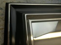 Mirror in black frame gilded with white gold leaf