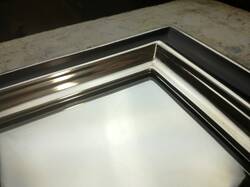 Mirror in black frame gilded with white gold leaf