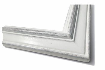 Corner of white distressed vintage frame – perspective view from below showing rounded outer edge and moulding depth with grey distressing on the carved section