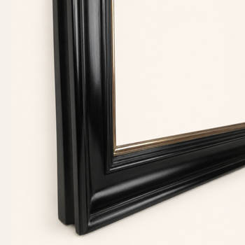 Black and gold picture frame at an angle: a wide, deep black moulding and a narrow gilded inner frame at the rabbet.